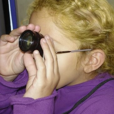girl testing her vision through lense girl testing her vision through lense