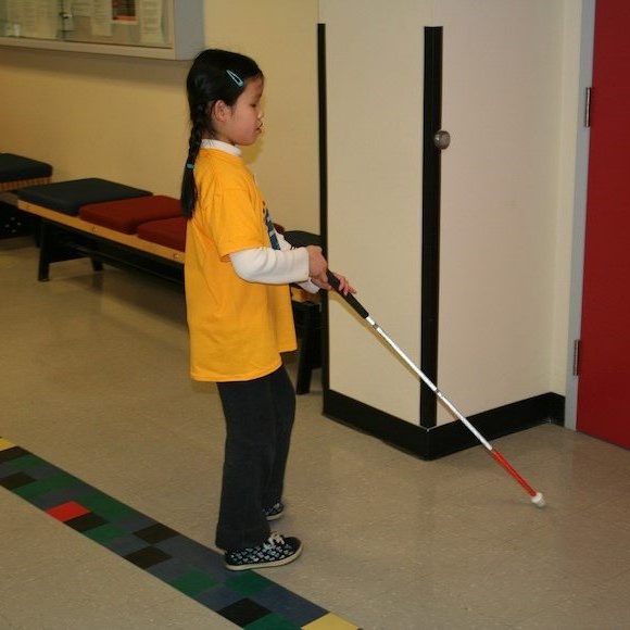 young girl practicing walking with a white cane young girl practicing walking with a white cane